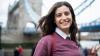 Portrait of smiling young woman in London in front of Tower Bridge.